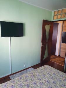 um quarto com uma cama e uma televisão de ecrã plano em Apartament Remali em Oradea