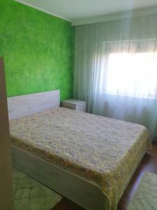 um quarto com uma cama com uma parede verde em Apartament Remali em Oradea