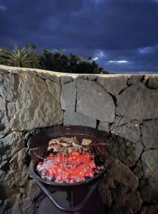 a barbecue grill in a stone wall at BUNGALOW APARTAMENTO SOL in Famara
