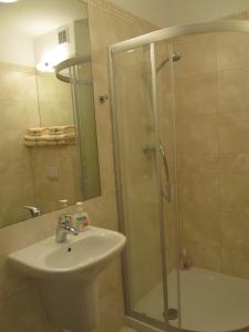 La salle de bains est pourvue d'une douche et d'un lavabo. dans l'établissement Apartament 22 nad morzem, à Świnoujście
