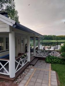 une terrasse couverte d'une maison avec une table et des bancs dans l'établissement Arolahti Suite ( Rapojärvi ), à Kouvola