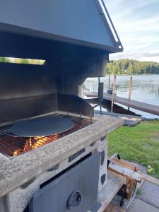 an outdoor grill with a grill at Arolahti Suite ( Rapojärvi ) in Kouvola