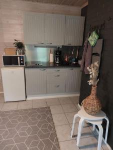 a kitchen with a vase on a chair in a kitchen at Arolahti Suite ( Rapojärvi ) in Kouvola