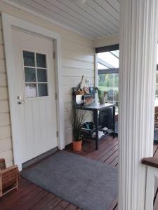 - une terrasse couverte avec une porte et une table avec un bureau dans l'établissement Arolahti Suite ( Rapojärvi ), à Kouvola