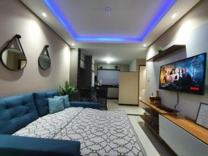 ein Wohnzimmer mit einem Bett und einem Fernseher in der Unterkunft Casa praia São José Antunes Maragogi in São José da Coroa Grande