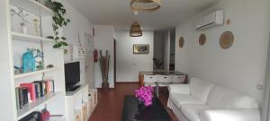 sala de estar con sofá blanco y mesa en PiedraNegra, apartamento completo con patio, terraza y BBQ, en Rodalquilar