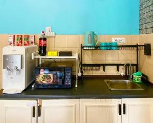 a kitchen counter with a sink and a microwave at RumahChantiqq at Ehsan waterpark, Port Dickson in Port Dickson