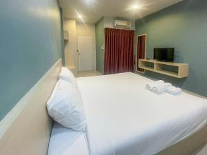 a bedroom with a large white bed with two towels at Hop On Phuket in Ban Bo Han
