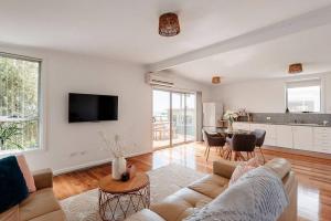 a living room with a couch and a table at House on Hampson in Penguin