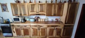 uma cozinha com armários de madeira e um micro-ondas em Pe-un Picior de Plai em Borca