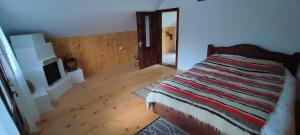 um quarto com uma cama e piso em madeira em Pe-un Picior de Plai em Borca