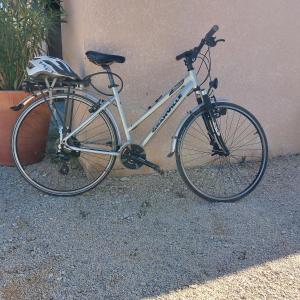 Una bicicleta está estacionada al lado de un edificio en Freundliches Haus mit Pool und großem Garten en Buis-les-Baronnies