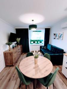 ein Wohnzimmer mit einem Tisch und einem Sofa in der Unterkunft Szmaragdowy Apartament nad Zalewem in Serock