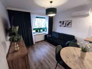 - un salon avec un canapé et une table dans l'établissement Szmaragdowy Apartament nad Zalewem, à Serock