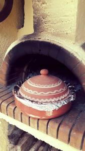 um bolo está sentado num forno de tijolos em Πέτρινος παραδοσιακός ξενώνας Αλεξάνδρα 