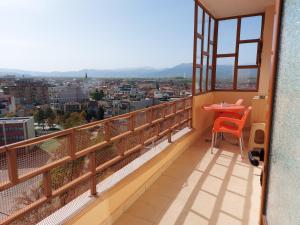 a balcony with a table and a view of a city at Geni Apartment in Korçë