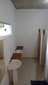 a bathroom with two sinks and a toilet at Chalés Vila Irerê Itaúnas in Itaúnas