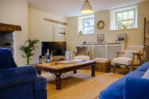 a living room with a table and a tv at Woodside Cottage - Cartmel Fell, Windermere in Windermere