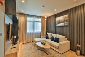 a living room with a couch and a table at A&H Hotel Apartment in Doha