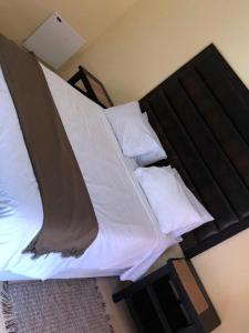 モコパネにあるPhokela Guest Houseのベッドルーム1室(大型ベッド1台、白いシーツ、枕付)