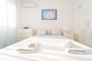 イラクリトサにあるVilla Dimitraの白いベッドルーム(タオル付きの白いベッド付)