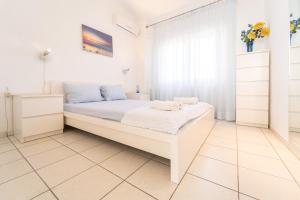 イラクリトサにあるVilla Dimitraの白いベッドルーム(白いベッド1台、窓付)
