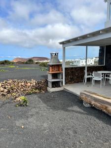 a patio with a stove and a table and chairs at El Cercado in Tinajo