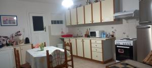 a kitchen with a table and a stove top oven at Balcony to Aegeon 3 in Apollon