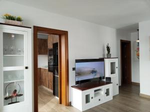 a living room with a flat screen tv on a cabinet at Casa Encarnación in Haría