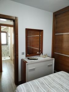 um quarto com uma cama e uma cómoda com um espelho em Casa Encarnación em Haría