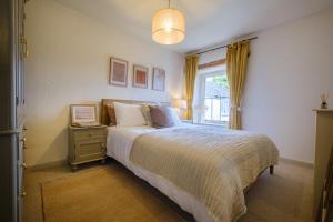 een slaapkamer met een groot bed en een raam bij Woodside Cottage - Cartmel Fell, Windermere in Windermere