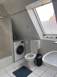 a bathroom with a toilet and a washing machine at Zirndorf Ferienhaus in Zirndorf