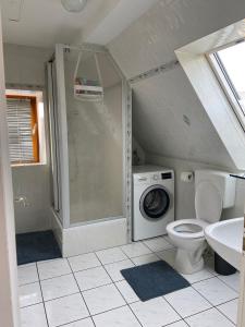 a bathroom with a toilet and a washing machine at Zirndorf Ferienhaus in Zirndorf