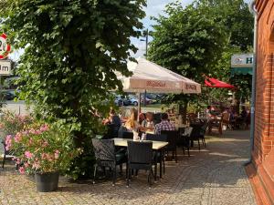 um grupo de pessoas sentadas em mesas num restaurante ao ar livre em Zur Eldenburg em Lübz