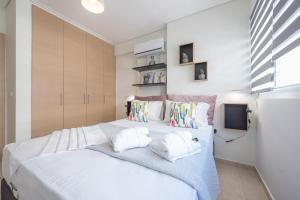 a bedroom with a large white bed with two pillows at Elegant Home with Balcony by CloudKeys in Athens