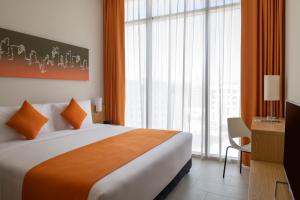 a hotel room with a large bed and large windows at Adagio Doha in Doha