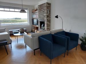 a living room with two chairs and a couch at Entre Deux Eaux in Lanaken