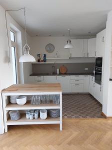 uma cozinha com armários brancos e um balcão com pratos em Entre Deux Eaux em Lanaken