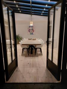 ein Esszimmer mit einem weißen Tisch und Glastüren in der Unterkunft Entre Deux Eaux in Lanaken