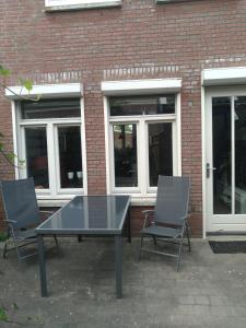 a table and two chairs in front of a brick building at etage met slaap, en badkamer in Sommelsdijk