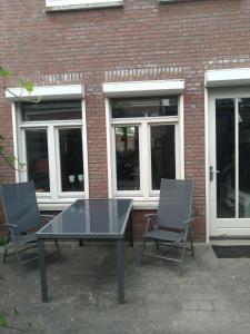 etage met slaap, en badkamer في Sommelsdijk: طاولة و كرسيين امام مبنى من الطوب