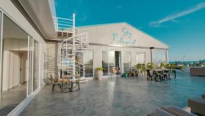 a building with chairs and tables on a patio at Lea Spa Hotel in Maafushi