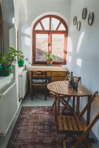 a room with a table and a desk and a window at The Dream House of Racos in Racoşu de Jos