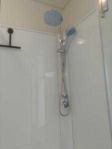 La salle de bains est pourvue d'une douche avec un pommeau de douche. dans l'établissement etage met slaap, en badkamer, à Sommelsdijk