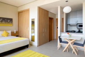 a hotel room with a bed and a kitchen at Adagio Doha in Doha