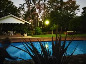a night view of a swimming pool in a yard at Tarentilos in Tzaneen