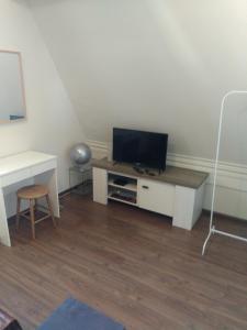 a living room with a tv and a desk at etage met slaap, en badkamer in Sommelsdijk