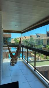 a hammock in a room with a view of a pool at Apto Joao Pessoa/Cabedelo in Cabedelo