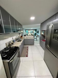 a large kitchen with stainless steel appliances and white tile floors at Apto Joao Pessoa/Cabedelo in Cabedelo