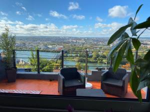 a balcony with two chairs and a view of a city at La colline bleue in Rouen